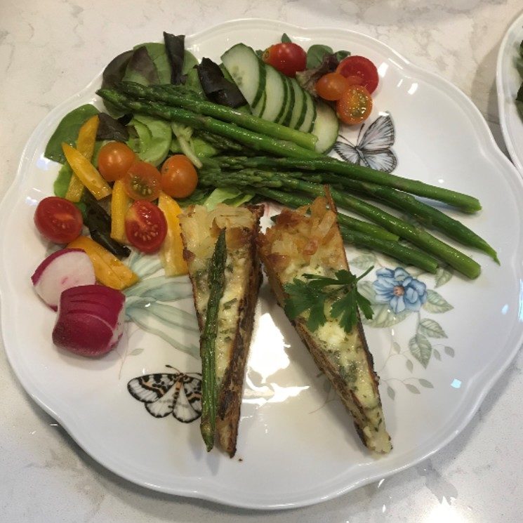 A hash brown bottom quiche served with asparagus and salad