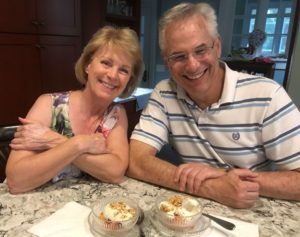 Woman and man smiling with peaches and ice cream snack.